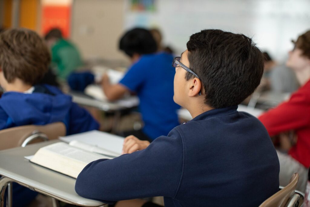 a student actively listening to the teacher while holding a bible