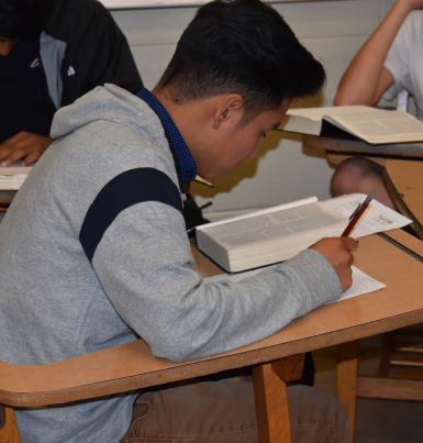 A bible student writing down notes during the program