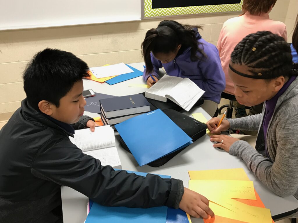 students helping each other during their bible lessons